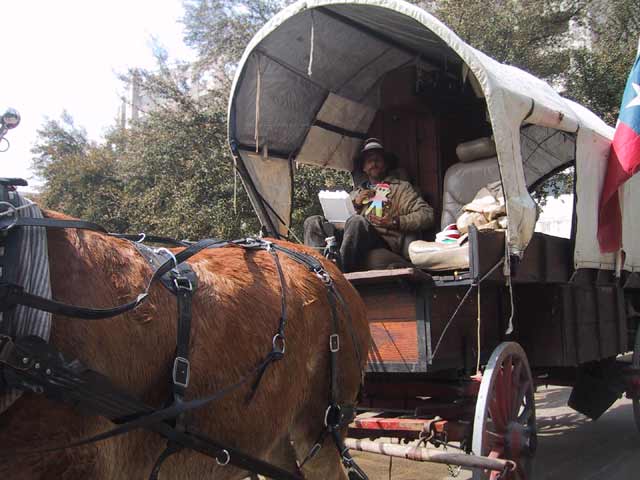 This cowboy was eating his lunch, but he didn't mind having a little boy sit in his lap at all.