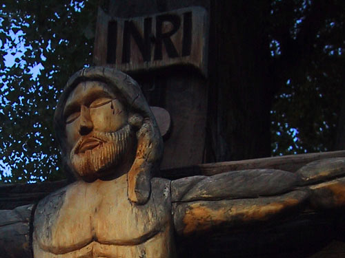 A wooden sculpture on the grounds of the church.