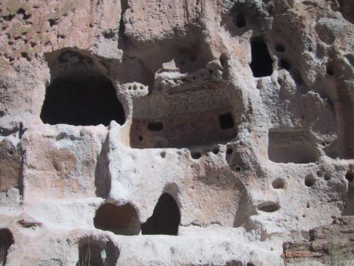Here are some dwellings. The small round holes are where beams were anchored. The caves are dug into soft volcanic rock, but they were only the back part of the homes. Actual wooden structures were the front part.